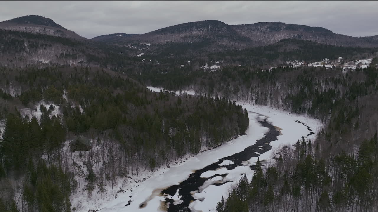 drones panorámicos aéreos hacia atrás desierto canadiense en pleno invierno cerca del norte de quebec stoneham estación de esquí de congelado sobre el río sautaurski con cabañas acogedoras y chalets