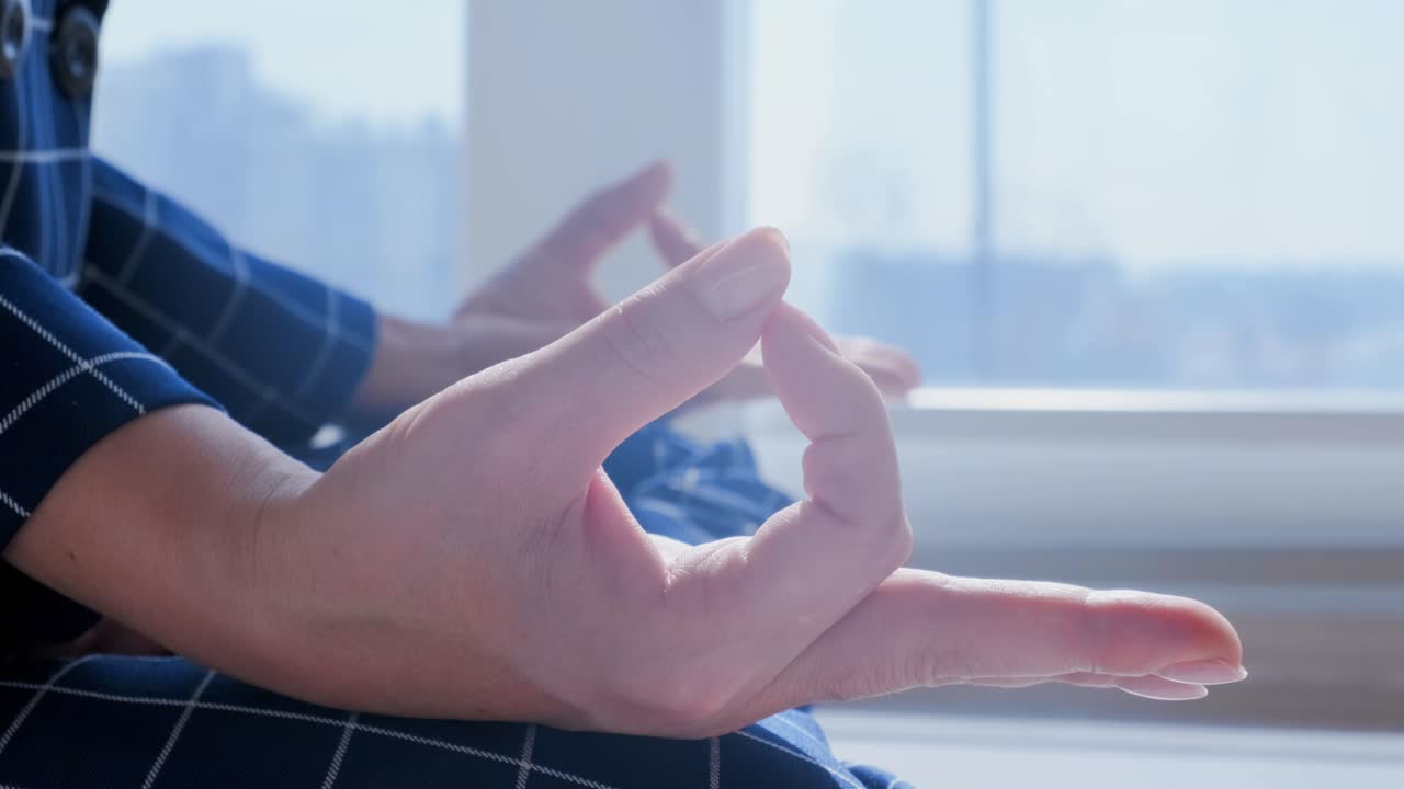 Businesswoman meditating by the window