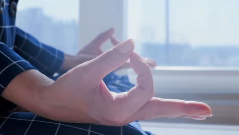 businesswoman meditating by the window