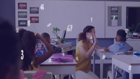 animation of numbers over diverse female teacher and schoolboy high fiving at desk in class