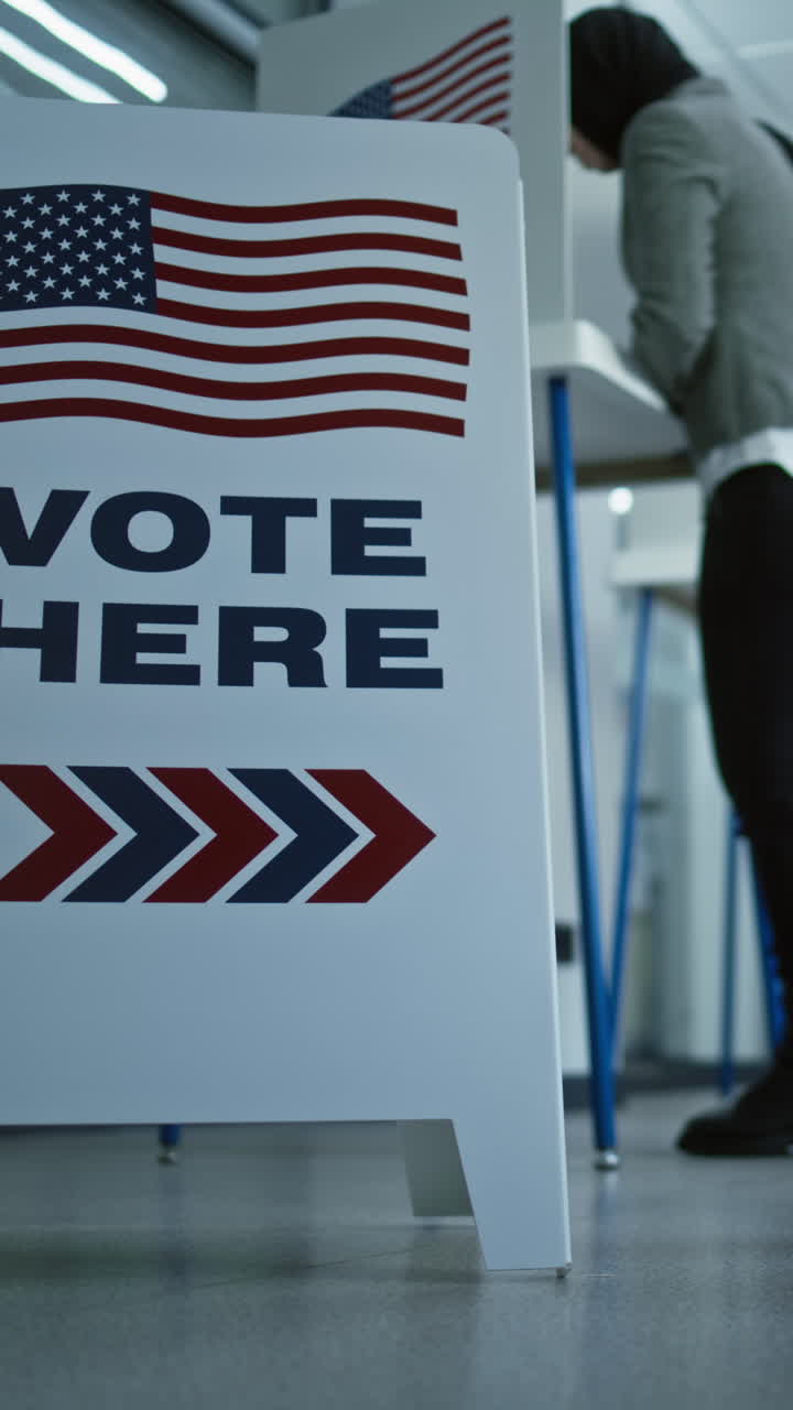 Vote here sign on the floor. Diverse American citizens vote in booths in polling station office. National Elections Day in the United States. Political races of US presidential candidates. Civic duty.