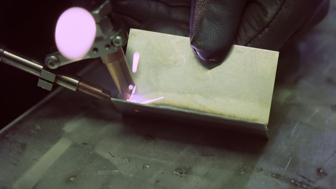 Macchina per saldatura laser con saldatore a pistola. La saldatura laser è mostrata in primo piano