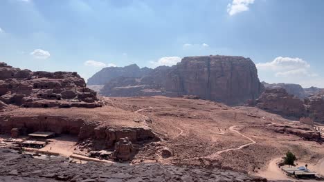 Petra-valley-in-Wadi-Musa,-Jordan-with-The-Treasury-in-the-middle-of-a-rocky-and-mountainous-landscape,-an-UNESCO-heritage-site,-ancient-Nabatean-Kingdom-4K-Establish-Shot