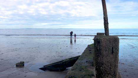 una madre y su hijo jugando en el agua en una playa