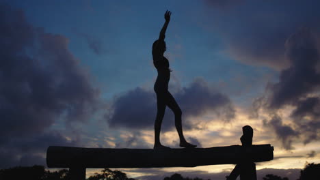 Silouette-Einer-Jungen-Frau-In-Yoga-Pose,-Meditierend,-Balancierend-Im-Hintergrund-Der-Abenddämmerung