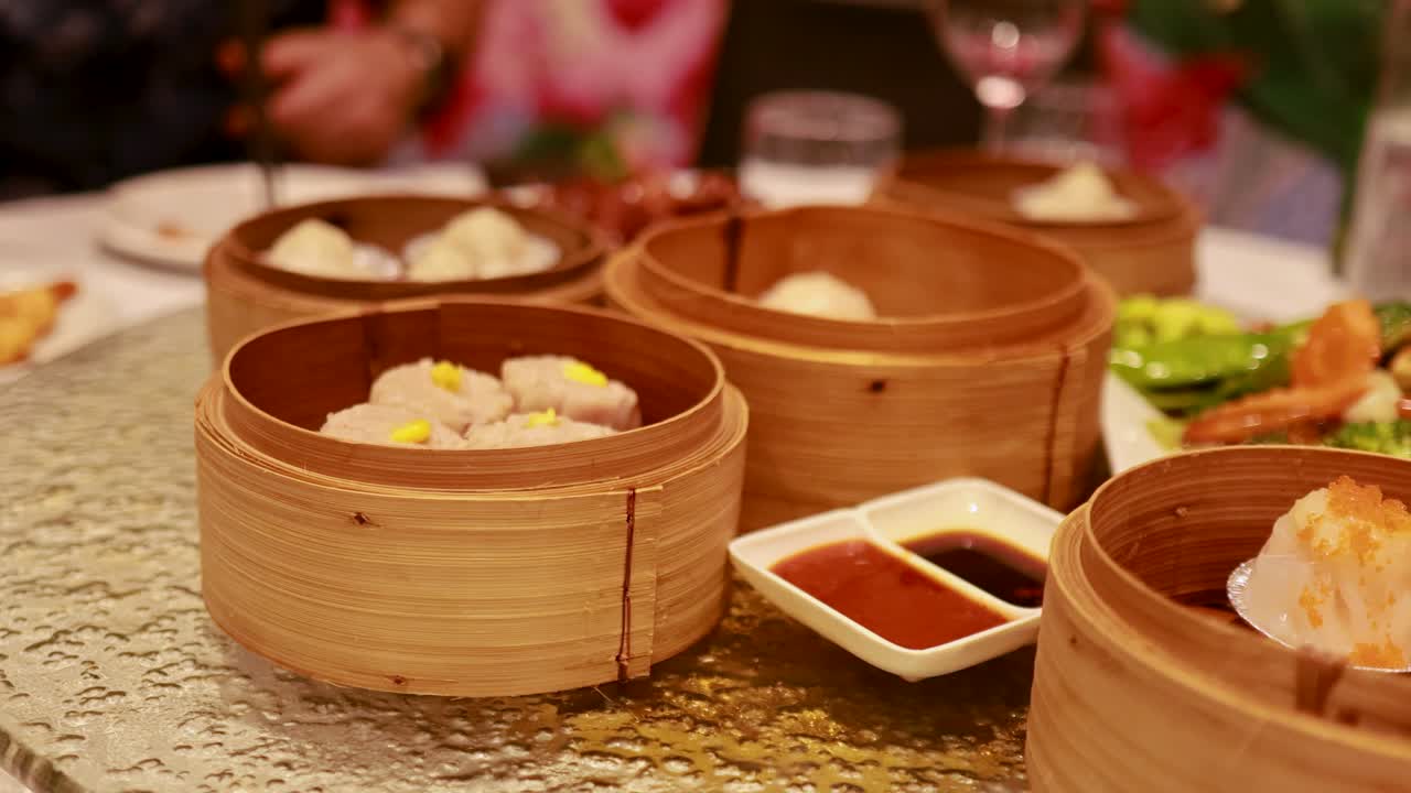 A vibrant table spread with dim sum, bamboo baskets, and sauces, capturing a lively dining experience