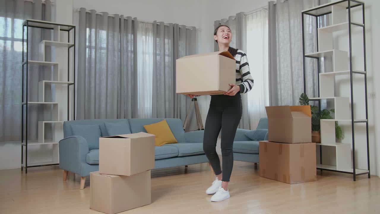 집 을 옮기는 동안 박스 를 흥분 하게 들고 있는 여자