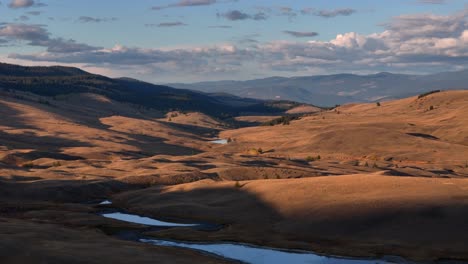 sunset over the grassland: aerial view of serene waters and majestic hills