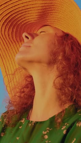 woman enjoying the sunset with a wide-brimmed hat