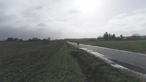 drone shot of motorcycle driving past