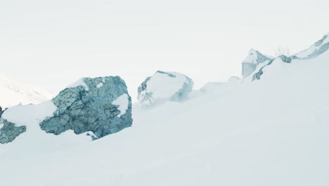 Lado-A-La-Vista-De-Un-Hombre-Esquiando-Más-Allá-De-La-Cámara-Entre-Rocas-En-Un-Frío-Día-De-Invierno