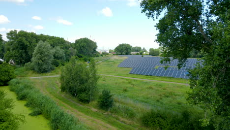 aerial flight over beautiful green solar panel farm renewable energy among trees