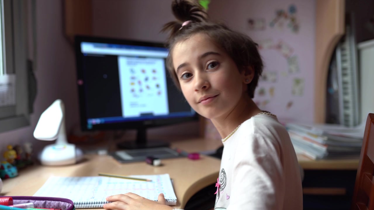 Menina de nove anos estudando e dançando em casa.
