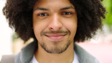 un joven estudiante negro feliz con un afro de pie