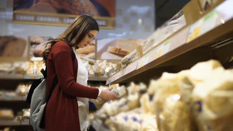 mujer comprando pan en una tienda de comestibles