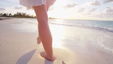 legs of barefoot caucasian female enjoying island sunset