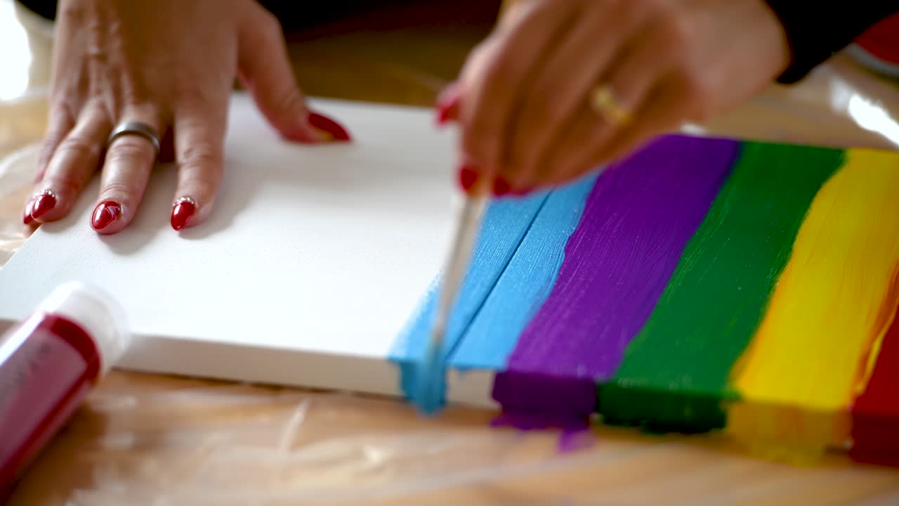 cerca de una mujer pintando rayas en un lienzo.