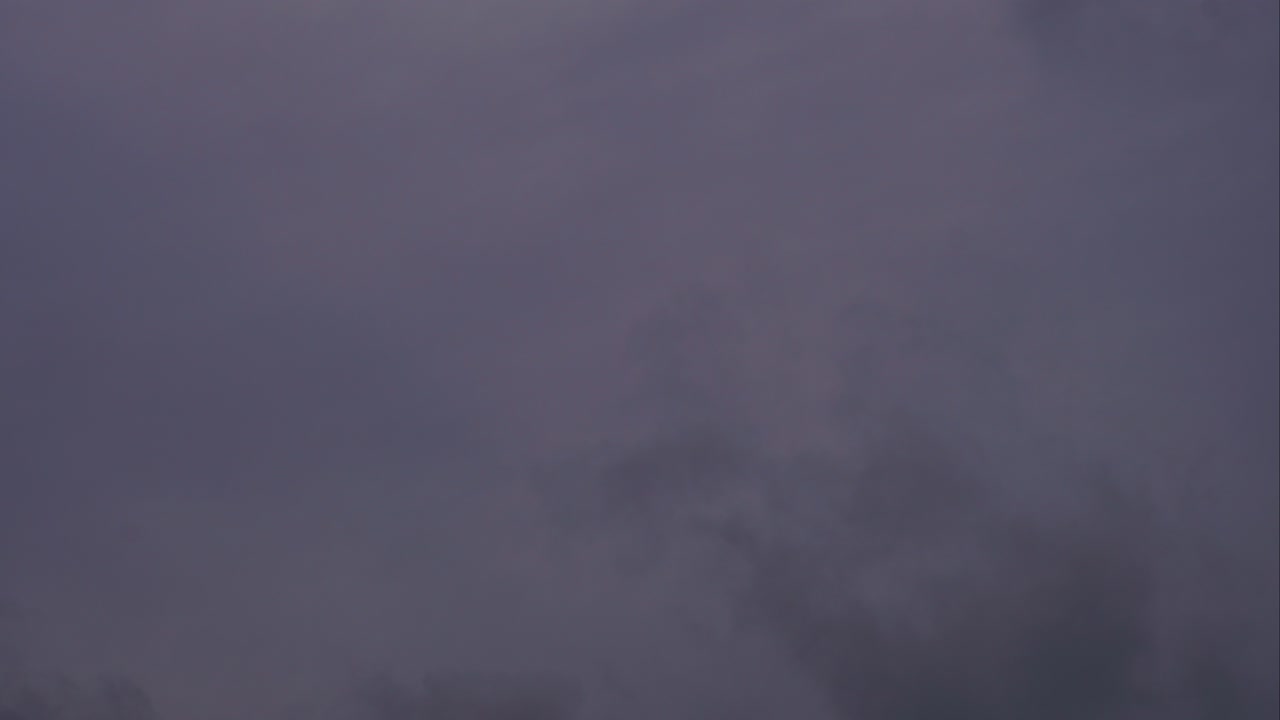 lapso de tiempo de nubes oscuras de tormenta que se mueven rápidamente en el cielo cubre el sol, letonia
