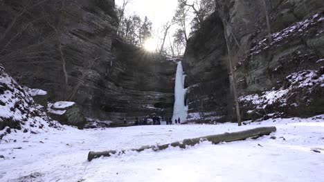 a wide shot of the frozen waterfall at wildcat canyon at starved rock state park with a sunstar