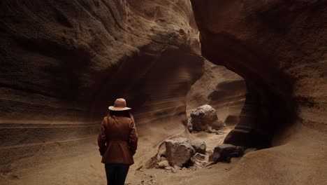 woman walking inside in ravine with big stones"