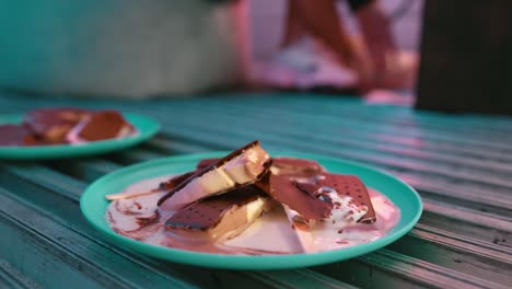 ice cream bars melted on a plate sitting on a reefer semi-truck with a lady in background adjusting her feet