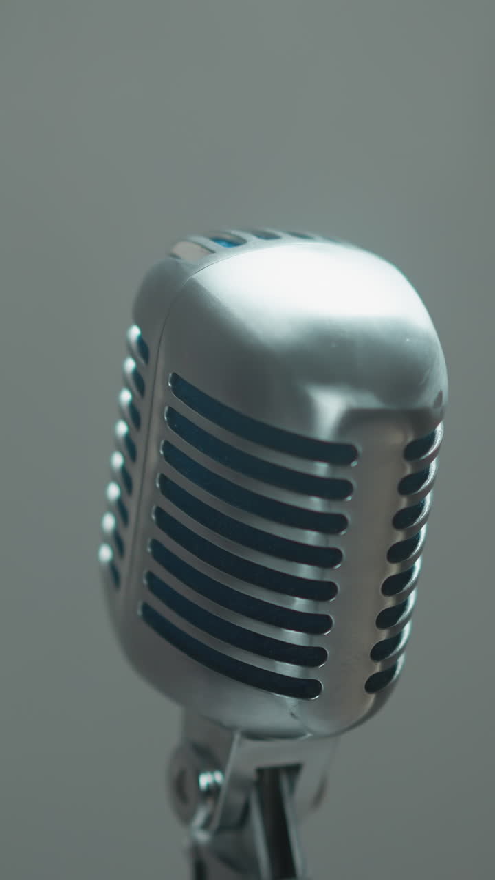 elegante micrófono vintage aislado contra un fondo gris suavemente borroso, capturando una estética minimalista