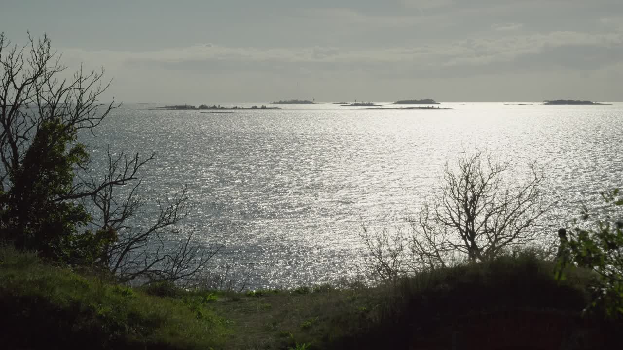 Stunning slow motion scenery of couple silhouette walking on hill in front of sparkling ocean