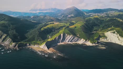 High-angle-aerial-panoramic-view-of-epic-eroded-flysch-geologic-cliffs-in-Playa-de-Sakoneta-in-Spain