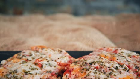 Delicious-cheesy-margherita-pizzas.-Tilt-down-studio-shot