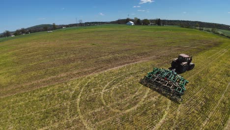 Tractor-Tirando-De-La-Máquina-Aradora-En-El-Campo-Agrícola-En-América-Durante-El-Día-Soleado