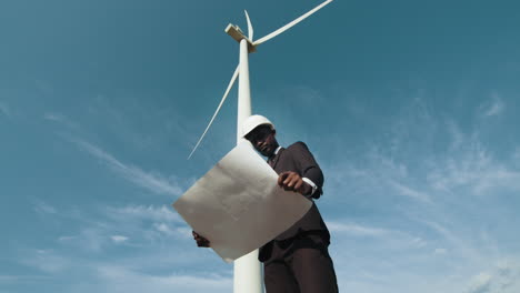 engineer reviewing blueprints for a wind turbine project
