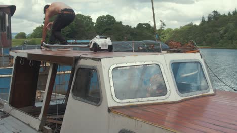 Topless-carpenter-hoovering-sanded-boat-cabin-roof