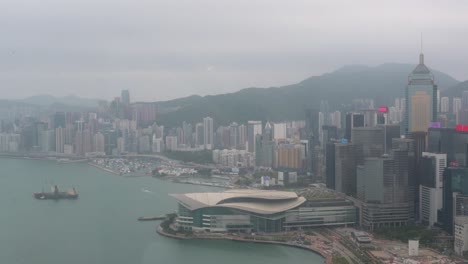 Aerial-city-view-during-a-foggy-dat-of-Hong-Kong's-financial-district,-skyline-and-skyscrapers-at-one-of-the-most-densely-populated-places-in-the-world