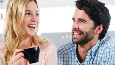 pareja sonriente tomando una taza de café