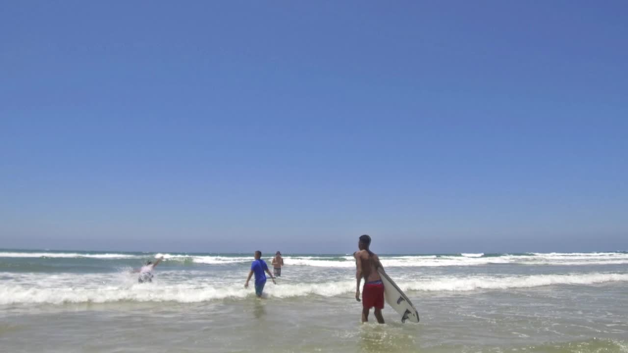 surfear en aguas poco profundas con adolescentes sudafricanos
