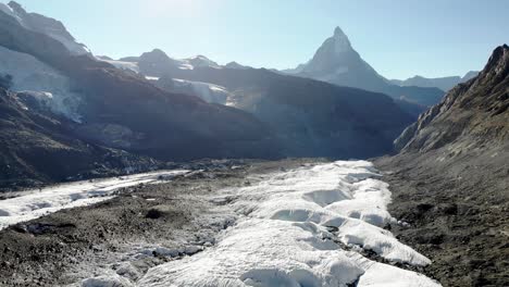Aerial-flyover-over-the-Gorner-glacier-at-Gornergrat-in-Zermatt,-Switzerland-with-a-view-panning-down-from-the-Matterhorn-to-an-overhead-view-of-the-icy-crevasses