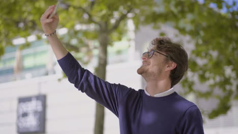 handsome happy man taking selfie with smartphone