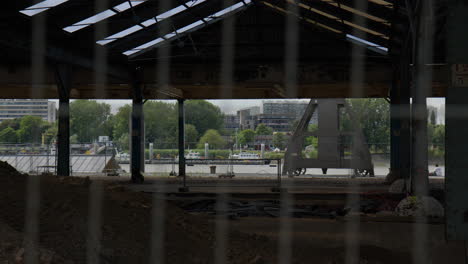 mirando a través del río scheldt detrás de la valla en el sitio de construcción en amberes, bélgica
