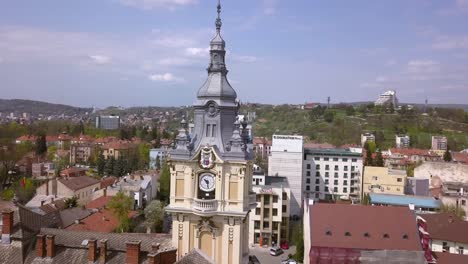 hermosa toma de drones aéreos golpeando una torre de reloj en el centro de cluj napoca rumania mientras revela la arquitectura de mediados de siglo