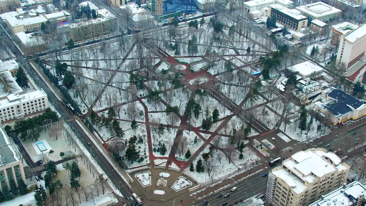 Aerial drone view of Chisinau downtown in winter, Moldova. Stephen the Great Park covered with snow, buildings, bare trees