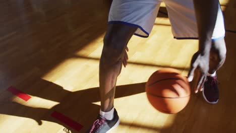 african american male basketball player practicing dribbling ball