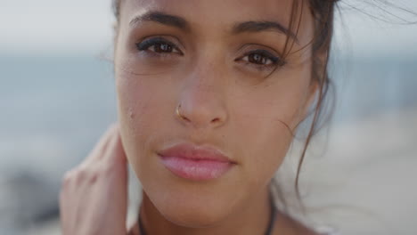 retrato de cerca hermosa joven mujer hispana con aspecto tranquilo corriendo con la mano a través del cabello soplando el viento mujer atractiva sonriendo piel perfecta sana belleza femenina cámara lenta