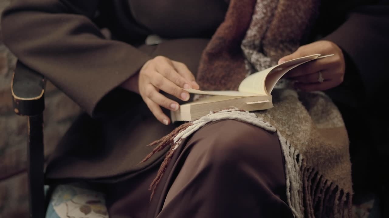 Primo piano di mani che girano le pagine mentre leggono un libro