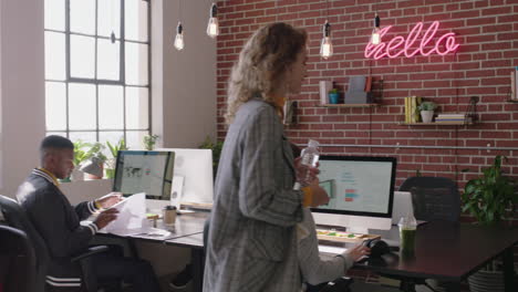 stylish-redhead-business-woman-team-leader-working-with-colleague-pointing-at-screen-sharing-ideas-enjoying-teamwork-in-successful-startup-marketing-company-office