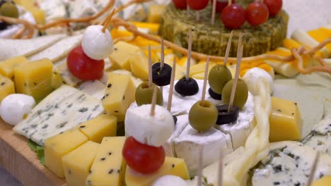 cheese board, pieces adorned with cherry tomatoes, olives, and mozzarella balls