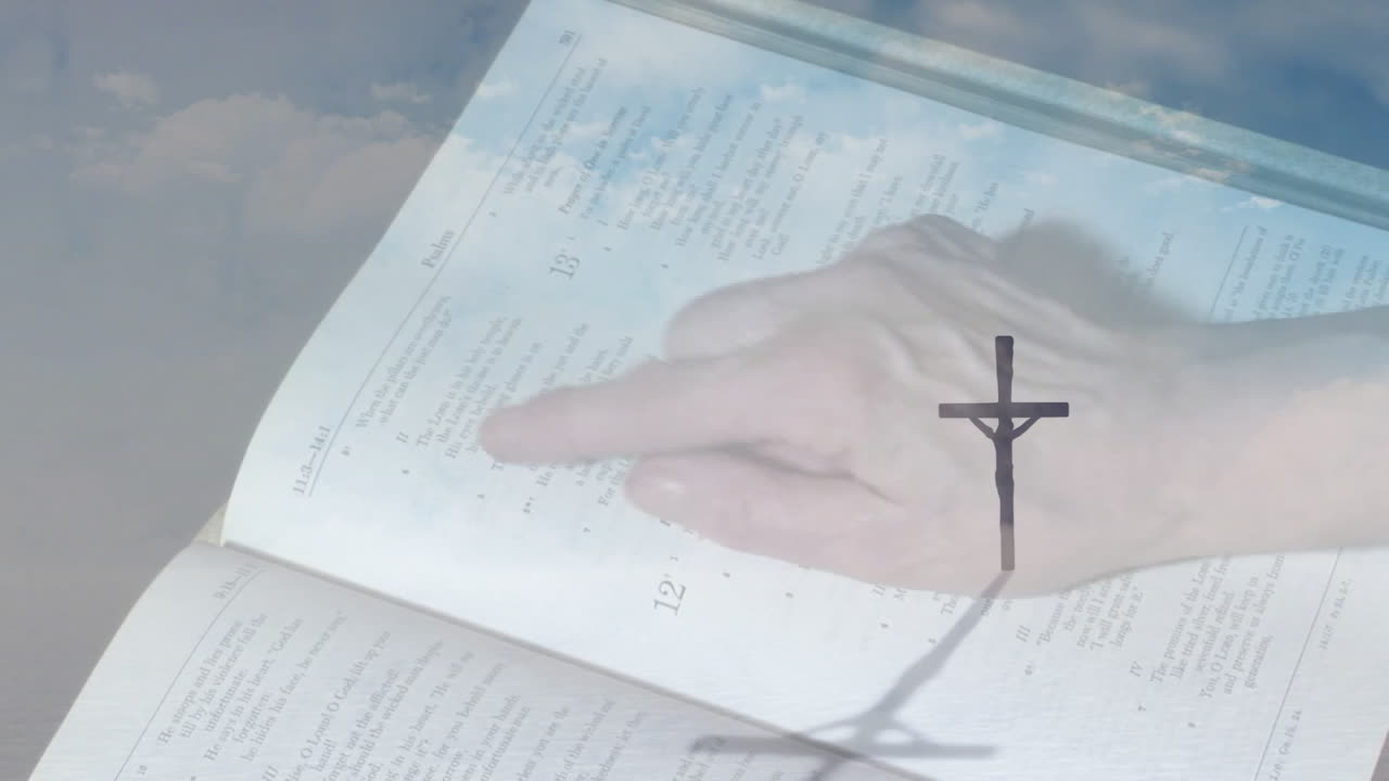 Hand pointing at open book with cross shadow, creating animation effect
