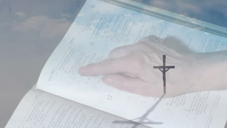 hand pointing at open book with cross shadow, creating animation effect