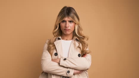 disappointed transgender woman nodding head against beige background