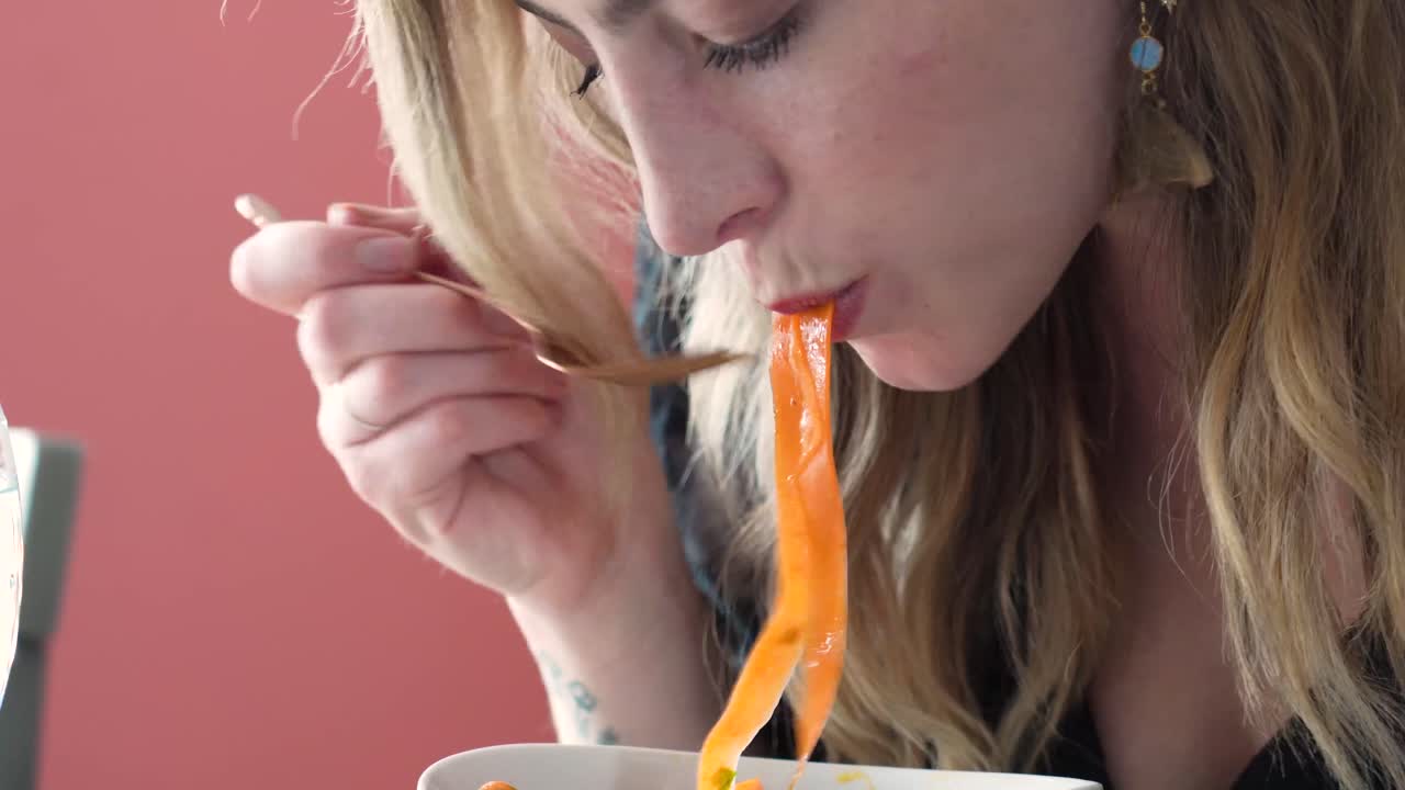 Donna caucasica che mangia squisita pasta al ragù