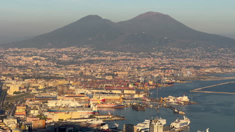 Panoramablick-Auf-Den-Geschäftigen-Hafen-Von-Neapel-Mit-Dem-Vesuv,-Der-Während-Der-Goldenen-Stunde-Im-Hintergrund-Aufragt